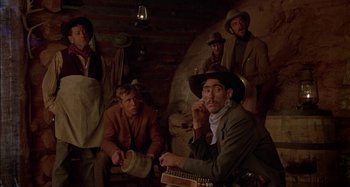 Movie still from “Butch and Sundance: The Early Days” (1979), directed by Richard Lester – A group of men sitting in a room; Medium shot, Low angle