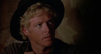 Movie still from “Butch and Sundance: The Early Days” (1979), directed by Richard Lester – A person wearing a hat and looking to his left; Close Up shot, Over the shoulder angle
