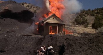 Movie still from “Butch and Sundance: The Early Days” (1979), directed by Richard Lester – A house on fire on the side of a mountain; Extreme Wide shot, Low angle