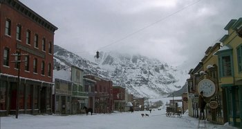 Movie still from “Butch and Sundance: The Early Days” (1979), directed by Richard Lester – A horse drawn carriage rides down a snowy street; Extreme Wide shot, High angle