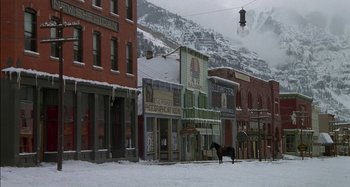 Movie still from “Butch and Sundance: The Early Days” (1979), directed by Richard Lester – A horse is standing in the middle of a snowy street; Extreme Wide shot, High angle