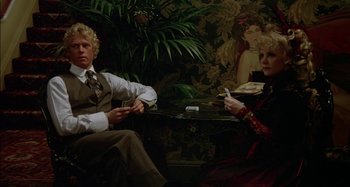 Movie still from “Butch and Sundance: The Early Days” (1979), directed by Richard Lester – A man and a woman sitting on a couch; Medium shot, Over the shoulder angle