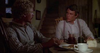 Movie still from “Butch and Sundance: The Early Days” (1979), directed by Richard Lester – Two men sitting at a dinner table shaking hands; Medium shot, Over the shoulder angle