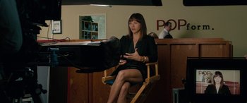 Movie still from “Celeste & Jesse Forever” (2012), directed by Lee Toland Krieger – A woman sitting in a chair in a room; Medium shot, Over the shoulder angle