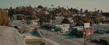 Movie still from “Celeste & Jesse Forever” (2012), directed by Lee Toland Krieger – An aerial view of a city street with buildings and trees in the background; Extreme Wide shot, High angle