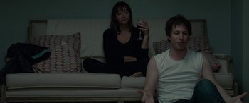 Movie still from “Celeste & Jesse Forever” (2012), directed by Lee Toland Krieger – A woman sitting on a couch holding a wine glass; Medium shot, High angle