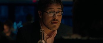 Movie still from “Celeste & Jesse Forever” (2012), directed by Lee Toland Krieger – A person wearing glasses and a suit; Close Up shot, Over the shoulder angle
