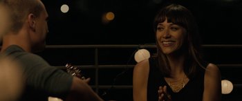 Movie still from “Celeste & Jesse Forever” (2012), directed by Lee Toland Krieger – A woman smiles while holding a microphone; Close Up shot, Over the shoulder angle