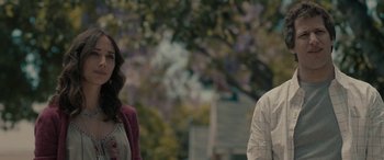 Movie still from “Celeste & Jesse Forever” (2012), directed by Lee Toland Krieger – A woman and a man standing next to each other in front of trees; Close Up shot, Over the shoulder angle