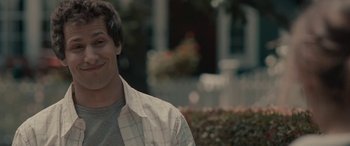 Movie still from “Celeste & Jesse Forever” (2012), directed by Lee Toland Krieger – A young man smiles while standing outside; Close Up shot, Over the shoulder angle