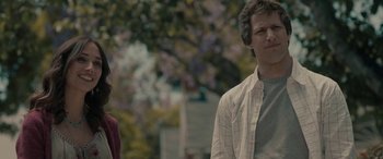 Movie still from “Celeste & Jesse Forever” (2012), directed by Lee Toland Krieger – A man and a woman standing next to each other in front of trees; Medium shot, Over the shoulder angle