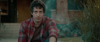 Movie still from “Celeste & Jesse Forever” (2012), directed by Lee Toland Krieger – A man in a plaid shirt is smoking a cigarette; Close Up shot, Over the shoulder angle