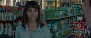 Movie still from “Celeste & Jesse Forever” (2012), directed by Lee Toland Krieger – A woman standing next to a shelf in a store; Close Up shot, Over the shoulder angle