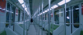 Movie still from “Code 46” (2003), directed by Michael Winterbottom – A person is walking on a subway train; Extreme Wide shot, High angle