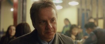 Movie still from “Code 46” (2003), directed by Michael Winterbottom – A person wearing a suit and tie; Close Up shot, Over the shoulder angle