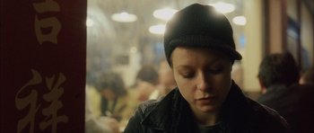 Movie still from “Code 46” (2003), directed by Michael Winterbottom – A person with a hat is looking down; Close Up shot, Over the shoulder angle