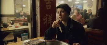 Movie still from “Code 46” (2003), directed by Michael Winterbottom – A woman sitting at a table with chopsticks in front of a bowl; Close Up shot, High angle
