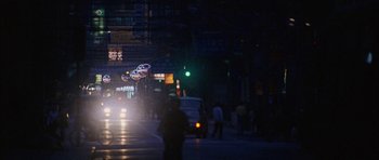 Movie still from “Code 46” (2003), directed by Michael Winterbottom – A city street at night lit by street lights; Extreme Wide shot, High angle