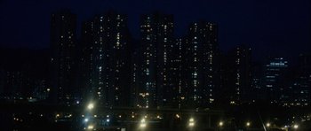 Movie still from “Code 46” (2003), directed by Michael Winterbottom – A view of a city at night with lights on buildings; Extreme Wide shot, High angle