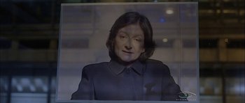 Movie still from “Code 46” (2003), directed by Michael Winterbottom – A woman in a black jacket is looking at the camera; Extreme Close Up shot, High angle