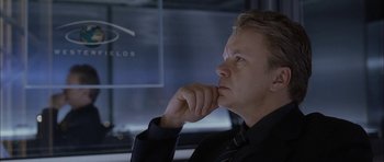 Movie still from “Code 46” (2003), directed by Michael Winterbottom – A man in a black shirt and a black tie; Close Up shot, Over the shoulder angle
