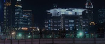 Movie still from “Code 46” (2003), directed by Michael Winterbottom – A group of people standing next to each other on top of a building; Extreme Wide shot, High angle