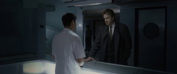 Movie still from “Code 46” (2003), directed by Michael Winterbottom – A man standing in front of a bathroom mirror; Medium shot, Over the shoulder angle