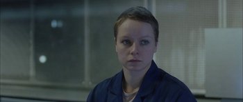 Movie still from “Code 46” (2003), directed by Michael Winterbottom – A woman with short hair is looking at the camera; Close Up shot, High angle