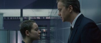 Movie still from “Code 46” (2003), directed by Michael Winterbottom – A man and a woman face to face in front of a building; Close Up shot, Over the shoulder angle