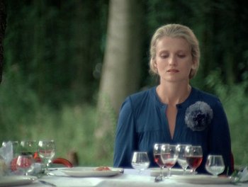 Movie still from “Cousin cousine” (1975), directed by Jean-Charles Tacchella – A woman sitting at a dinner table with wine glasses; Medium shot, Over the shoulder angle