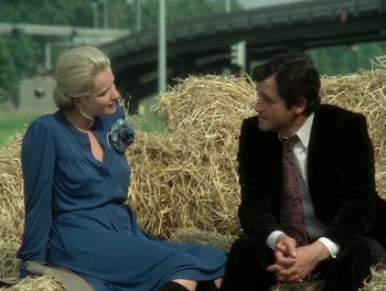 Movie still from “Cousin cousine” (1975), directed by Jean-Charles Tacchella – A man and a woman are sitting on hay bales; Medium shot, Over the shoulder angle