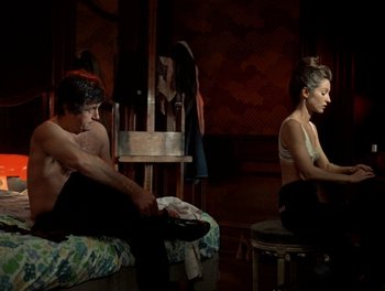 Movie still from “Cousin cousine” (1975), directed by Jean-Charles Tacchella – A man and a woman sitting in a room; Medium shot, High angle