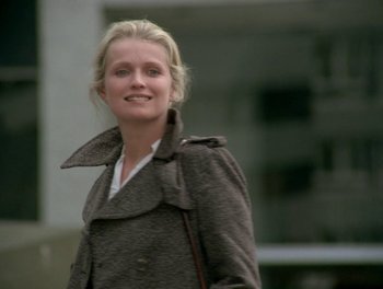 Movie still from “Cousin cousine” (1975), directed by Jean-Charles Tacchella – A woman in a brown coat smiling for the camera; Close Up shot, Low angle