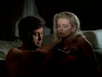 Movie still from “Cousin cousine” (1975), directed by Jean-Charles Tacchella – A man and a woman in a dark room; Medium shot, High angle