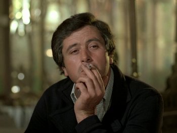 Movie still from “Cousin cousine” (1975), directed by Jean-Charles Tacchella – A man smoking a cigarette while wearing a jacket; Close Up shot, Low angle