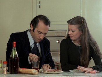 Movie still from “Cousin cousine” (1975), directed by Jean-Charles Tacchella – A man and a woman sitting at a dinner table; Medium shot, Low angle