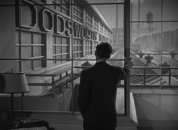 Movie still from “Dodsworth” (1936), directed by William Wyler – A black and white photo of a man looking out of a window; Extreme Wide shot, High angle