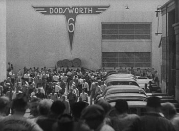 Movie still from “Dodsworth” (1936), directed by William Wyler – A black and white photo of a group of people standing in front of a building; Extreme Wide shot, High angle