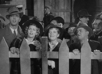 Movie still from “Dodsworth” (1936), directed by William Wyler – A group of men and women standing next to each other in front of a fence; Medium shot, High angle