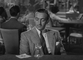 Movie still from “Dodsworth” (1936), directed by William Wyler – A black and white photo of a man sitting at a table with a glass of wine; Close Up shot, High angle