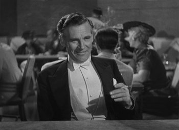 Movie still from “Dodsworth” (1936), directed by William Wyler – An older man smoking a cigarette while sitting at a table; Close Up shot, High angle