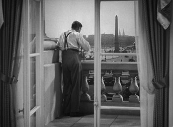 Movie still from “Dodsworth” (1936), directed by William Wyler – A man standing on a balcony looking out at a city; Medium shot, Low angle
