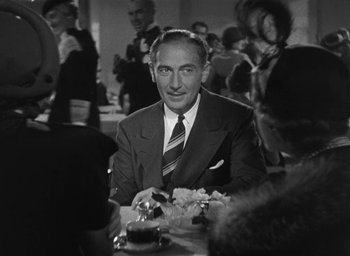 Movie still from “Dodsworth” (1936), directed by William Wyler – A man sitting at a table with a plate of food; Medium shot, Over the shoulder angle