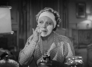 Movie still from “Dodsworth” (1936), directed by William Wyler – An older woman putting a face mask on her face; Close Up shot, Over the shoulder angle