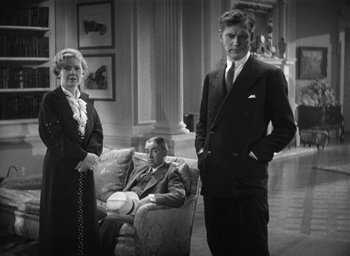 Movie still from “Dodsworth” (1936), directed by William Wyler – An older man and woman standing next to a man in a suit and tie; Medium shot, Low angle