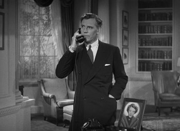 Movie still from “Dodsworth” (1936), directed by William Wyler – A man in a suit talking on a phone; Medium shot, High angle
