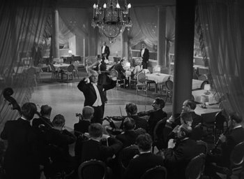 Movie still from “Dodsworth” (1936), directed by William Wyler – An orchestra performing in a large room with a chandelier; Wide shot, Low angle