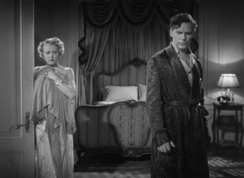 Movie still from “Dodsworth” (1936), directed by William Wyler – A man and a woman standing next to each other in front of a bed; Medium shot, Low angle