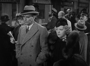 Movie still from “Dodsworth” (1936), directed by William Wyler – A man and a woman standing next to each other in a crowd; Medium shot, Low angle