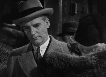 Movie still from “Dodsworth” (1936), directed by William Wyler – A man in a suit and a hat is standing next to a cat; Close Up shot, Over the shoulder angle